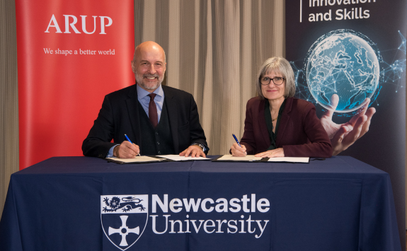 Andy Mace, Arup and Professor Stephanie Glendinning Newcastle University sign the partnership agreement at a table 
